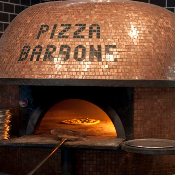 a stove top oven sitting next to a brick wall
