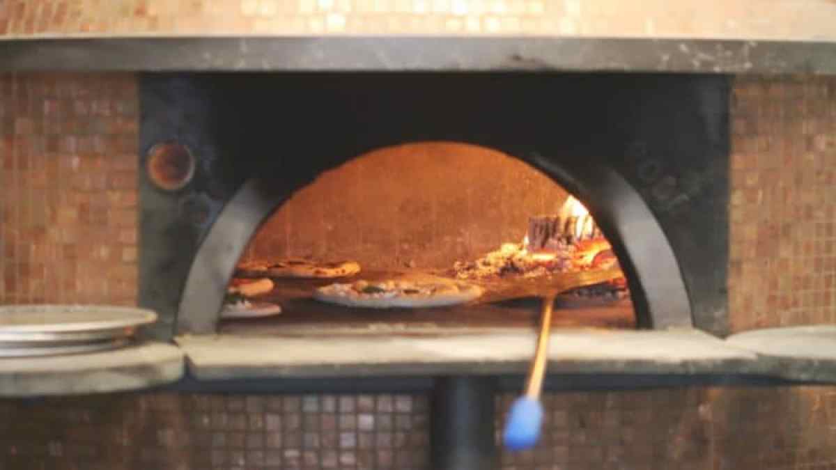 a stove top oven sitting inside of a pizza on a grill